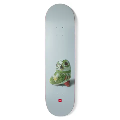 Chocolate Capps Porcelain skateboard deck: Photograph of a small green-glazed ceramic owl figure on a pale grey-blue deck, with the red Chocolate logo near the tail.