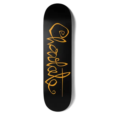 Chocolate Fernandez OG Script skateboard deck: Flowing looped Chocolate script in orange runs the length of a plain black deck, ending in a long underline stroke.