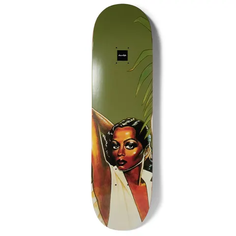 Chocolate Aikens Queen skateboard deck: Painted portrait of a woman with dark eye make-up and arms raised behind her head, in a cream open-collared top, with palm fronds on an olive green background. Small black Chocolate logo near the nose.