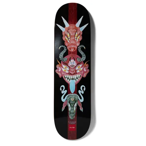 Chocolate Aikens Dog Perfume Mask skateboard deck: Vertical totem of three folk-art demon masks, a horned red dragon head, a fanged red demon with blue tongue and a green creature with snakes, over a dark red stripe on black. Small name text and Chocolate logo at the bottom.