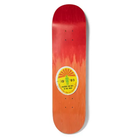 Girl Bennett Ripened skateboard deck: Peeling oval fruit-style sticker with a yellow sunburst, a green Girl figure and the text 19 93 FRAGRANT AND SOFT TO THE TOUCH, set on a red to orange faded wood stain.