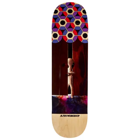 Alien Workshop Visitor Doorway skateboard deck: Photographic scene of a small grey alien peering around a partly open dark wooden door onto a colourful carpet, with a hexagonal pattern of red, purple, blue and cream at the nose and natural maple wood at the tail.