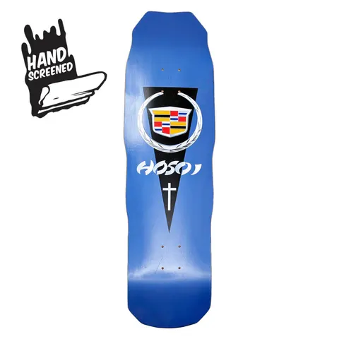 Hosoi Cadillac skateboard deck: A Cadillac-style crest in a laurel wreath on a black downward-pointing pennant, with the Hosoi name in white and a small cross below, on a blue shaped deck. A hand screened badge sits in the corner of the photo.
