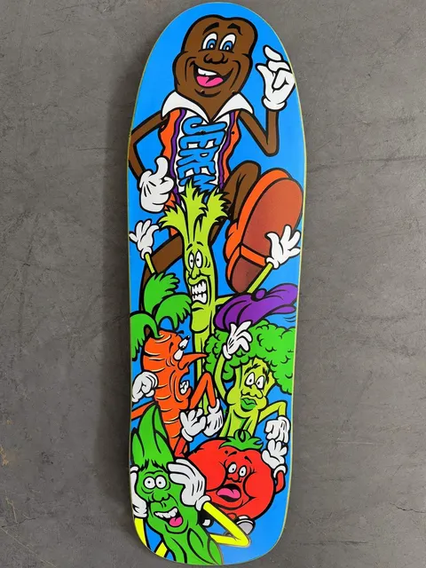 Hook-Ups Jk Industries Jeremy Klein Candy Bar skateboard deck: Cartoon chocolate bar character in an orange and blue jersey, strutting over a pile of panicking cartoon vegetables including celery, carrot, broccoli, tomato and lettuce, on a bright blue old-school shaped deck.