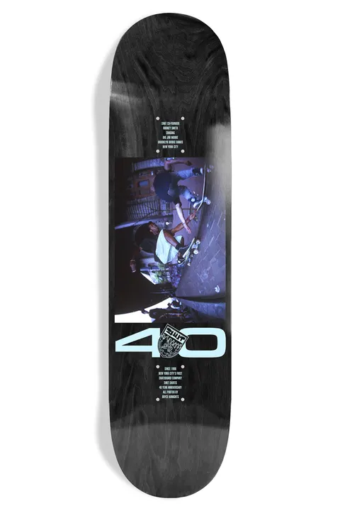 Shut Bryce Kanights Rodney EX7 skateboard deck: A dusky blue-toned photograph of skaters in a New York street, with a large pale blue 40 and a small crest below it, on a black-stained deck. Small blocks of credit text sit above and below the picture.
