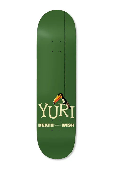 Deathwish Yuri Tropipop 8.25 skateboard deck: Toucan perched on a hanging line above large cream serif lettering reading Yuri, with Deathwish International beneath, on a dark green deck.