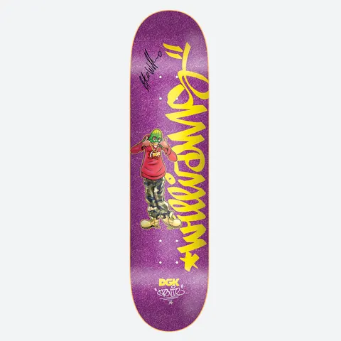 DGK Autographed Cheesin Stevie 8.38 skateboard deck: A cartoon figure in a green mask, red hoodie and camouflage trousers posing with thumbs up, beside large yellow graffiti-style lettering running down a glittery purple deck. A black signature is near the nose and a DGK logo at the tail.