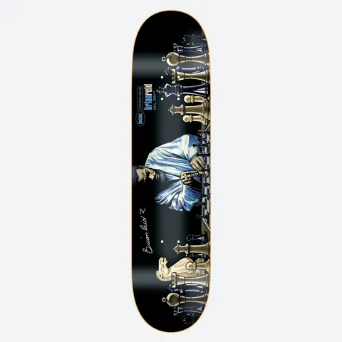 DGK Autographed Next Move Reid 8.25 skateboard deck: Black deck showing a figure in a pale blue robe seated at a long chess board, with large gold and dark chess pieces lining both ends. A printed signature sits near the tail, and the DGK and rider logo near the nose.