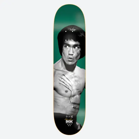 DGK x Bruce Lee Emerald Golden Dragon Lenticular skateboard deck: Black and white photograph of a shirtless martial artist with claw scratches across his chest and cheek, looking to the side on an emerald green background. Chinese characters, a signature and the brand logo sit at the bottom.