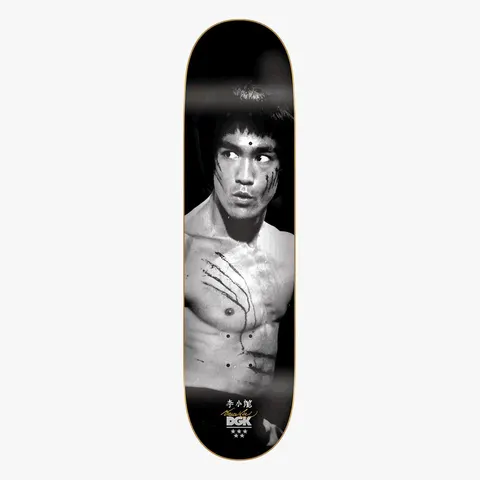 DGK x Bruce Lee Golden Dragon Lenticular skateboard deck: Black and white photograph of a shirtless martial artist with claw scratches across his chest and cheek, glancing to the side against a black background. Chinese characters, a signature and the brand logo sit at the bottom.