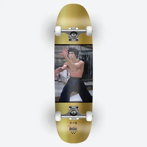 DGK x Bruce Lee Like Echo Foil Cruiser skateboard deck: Photograph of a shirtless martial artist in a fighting stance, set in a black-bordered panel across a gold foil cruiser deck, with Chinese characters, a signature and the DGK logo at the tail. Shown as a complete with trucks.
