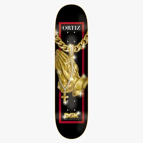DGK Iced Ortiz 8.38 skateboard deck: Black deck with a gold pair of praying hands on a chunky gold chain with a diamond-studded rosary and cross, sparkling. A red frame, the rider name at the top and a gold DGK logo at the bottom.