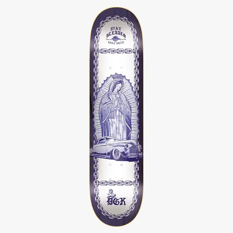 DGK Lo - Side Ortiz 8.5 skateboard deck: Blue-and-white religious scene of the Virgin of Guadalupe in a halo of rays, with a lowrider car at her feet, framed by chains on a white deck. Stay Blessed lettering at the top and a rose and DGK logo at the foot.