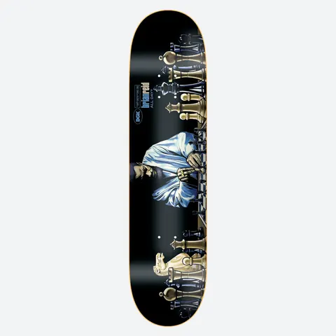 DGK Next Move Reid 8.25 skateboard deck: Man in a white shirt seated at a long chessboard, flanked by large gold and black chess pieces, on a black deck. DGK logo and brian reid ALL DAY text in blue near the top.