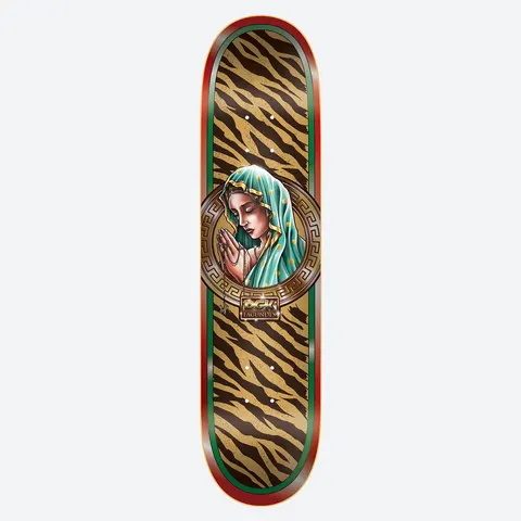 DGK Santa De Oro Fagundes 8.25 skateboard deck: A praying Madonna in a teal veil with gold stars is framed in a circular Greek key medallion, over a tiger-stripe pattern in tan and brown with red and green borders. A small gold DGK plaque sits below.