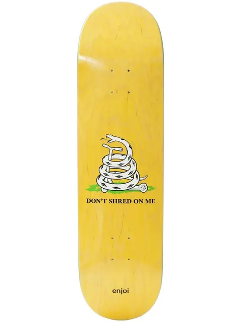 Enjoi dont shred board skateboard deck: Parody of the Gadsden flag: a white coiled snake on a patch of grass, its tail ending in a skateboard wheel, with 'DON'T SHRED ON ME' beneath. Enjoi wordmark at the tail on a yellow woodgrain.