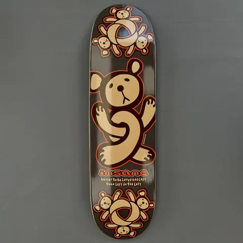 Insane Twisted Teddy skateboard deck: A large tan teddy bear with orange outline, its legs twisted into a knot, with clusters of small bears around knotted rings at top and bottom on a dark brown deck.