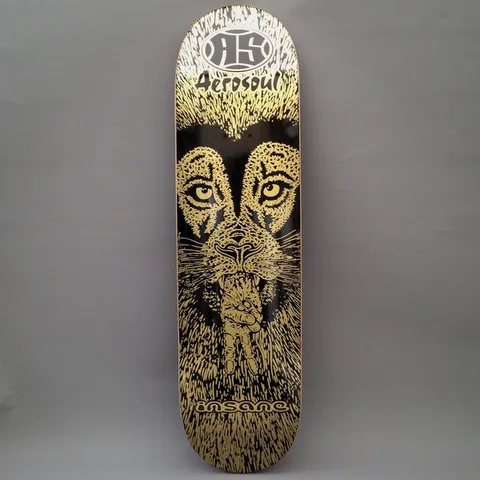 Insane Insane x Aerosoul Peaceful Lion skateboard deck: Gold line-drawn lion's face on black with intense eyes, making a peace sign with a hand held at its mouth, within a fur-like texture. The Aerosoul logo is at the top and Insane at the bottom.