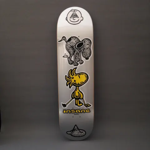 Insane Snooper Scooper skateboard deck: Silver deck with a stack of cartoon characters: a round face with an eye-in-pyramid, a scruffy black-and-white dog, a yellow bird holding a hockey stick, and a pyramid-eye mark at the tail, above the Insane logo.