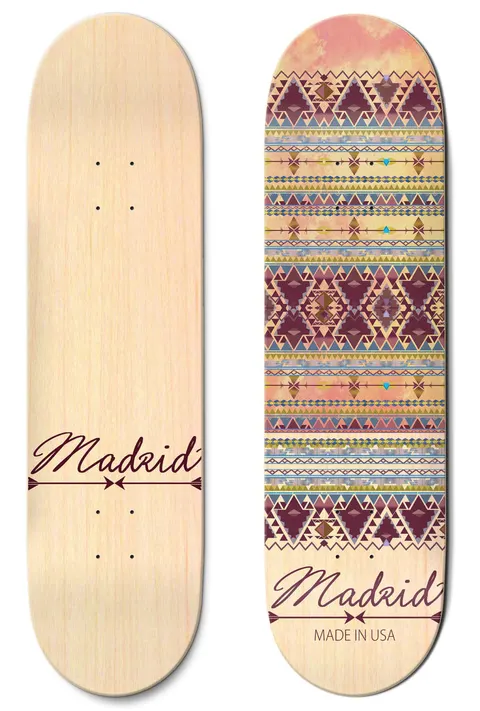 Madrid Indie 8 skateboard deck: A band pattern of Aztec or tribal-style diamonds and zigzags in maroon, mustard, blue and pink over a sunset-pink sky on a natural maple deck. Madrid script logo with arrow at the bottom; the other deck shown is plain wood.