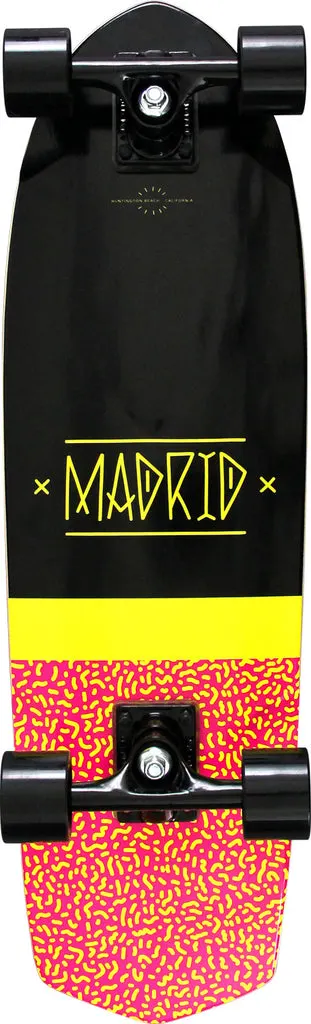 Madrid Picket 28.5 skateboard deck: A black cruiser deck with MADRID in yellow hand-drawn capitals between crosses, above a yellow band and a pink tail with a yellow squiggle pattern. Shown as a complete with black trucks and wheels.