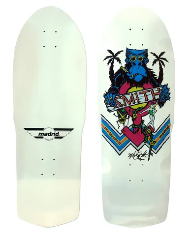 Madrid Retro Mike Smith Ape skateboard deck: Old-school shaped white deck showing a blue gorilla with round glasses and a cigar between palm trees, holding a banner reading 'SMITH', with a pink circle, a small green pin-up girl, a tiki figure and blue striped chevrons. Plain white bottom with Madrid winged logo.