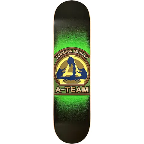 A-Team Gershon Mosley Crest skateboard deck: Military-style round crest in olive, brown and yellow with a blue stylised A emblem, ringed by the rider name above and A-Team below. A bright green spray fade glows behind it on a black deck.