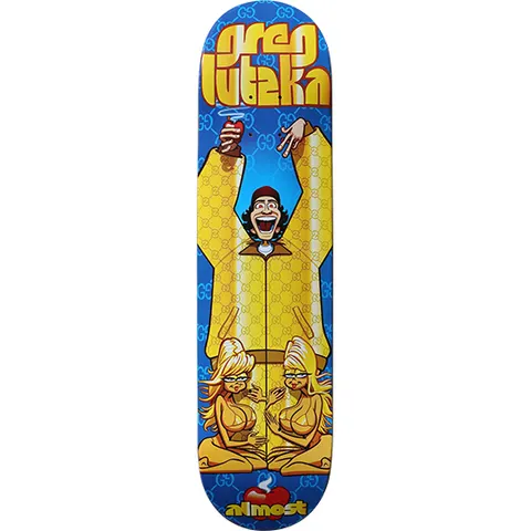 Almost Greg Lutzka Gucci Suit skateboard deck: Cartoon of a laughing man in a yellow tracksuit, arms raised with a drink, over a blue deck with a repeating monogram pattern. Two blonde cartoon women sit cross-legged below, and the name Greg Lutzka is in yellow lettering at the top.