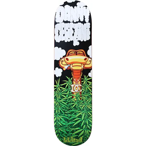Blind Danny Cerezini Snake in the Grass skateboard deck: A cartoon cobra with a joint in its mouth and a gold chain pendant rises from a field of cannabis leaves, with white bubble-letter Danny Cerezini lettering formed from smoke clouds above. Blind logo at the tail.