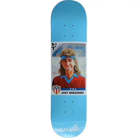Cliché Joey Brezinski World Cup Series skateboard deck: Football sticker-card style painted portrait of a smiling man with a mullet and blue headband, wearing a red jumper, with a USA shield and name caption, on a sky blue deck. Cliché logo at the tail.