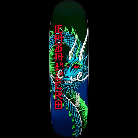 Powell Peralta Caballero Ban This Dragon Green/Blue skateboard deck: Blue and green dragon with red eyes and white horns coiled down a dark green to navy deck, with vertical red Chinese-style characters spelling Caballero on the left.