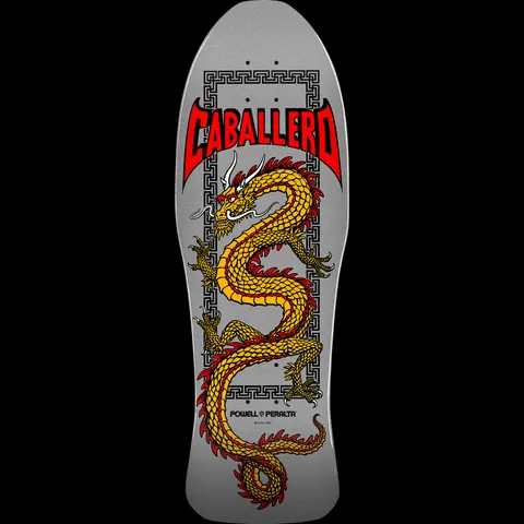 Powell Peralta Caballero Chinese Dragon Silver skateboard deck: Gold dragon with red fringes coiling down the deck inside a Greek key border, under red bat-winged Caballero lettering, on a silver deck.