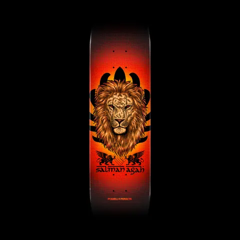 Powell Peralta Pro Salman Agah Lion - Shape 242 skateboard deck: A detailed illustrated lion's head with a golden mane in front of black leaf-like shapes, with two small winged griffins beneath. The background glows from orange-red to black with a subtle maze pattern.