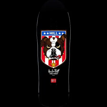 Powell Peralta Frankie Hill Bulldog Black skateboard deck: Old-school shaped black deck with a shield showing a scowling bulldog with a bone on its head, spiked collar and sheriff star, set against red and white stripes under a blue star banner reading HILL. A signature and red 911 badge sit below.