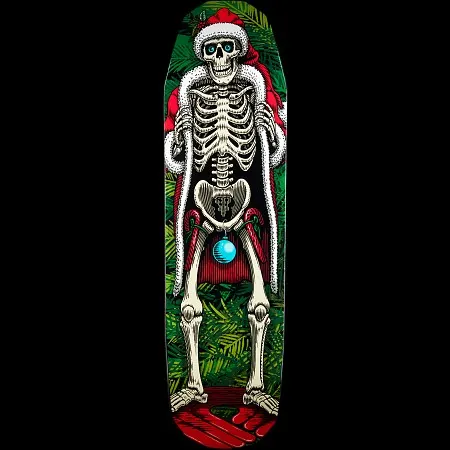 Powell Peralta Holiday 2014 skateboard deck: A skeleton wearing a Santa hat and a red, white-trimmed cloak held open stands among fir branches, with a blue bauble hanging at its pelvis. Red presents or ribbon fill the bottom of the deck.