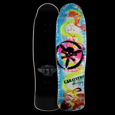 Powell Peralta Caballero Stencil - Cab Stencil skateboard deck: Spray-paint stencil style graphic of a black skull with a propeller-like cross inside a circle, over blue, pink, lime and orange paint splashes and tags. The name is in green stencil lettering near the tail.