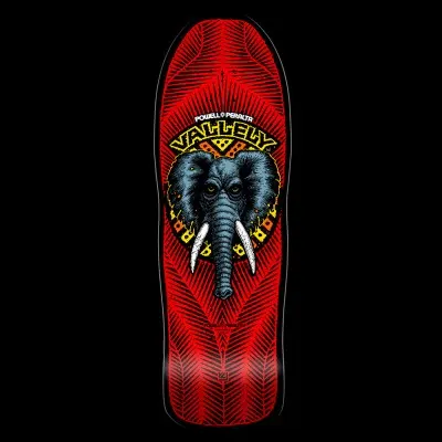 Powell Peralta Vallely Elephant - Red skateboard deck: A grey elephant head with white tusks and yellow eyes inside a yellow and orange tribal-style ring, under 'Vallely' lettering, on a red deck patterned with fine black feather-like lines.