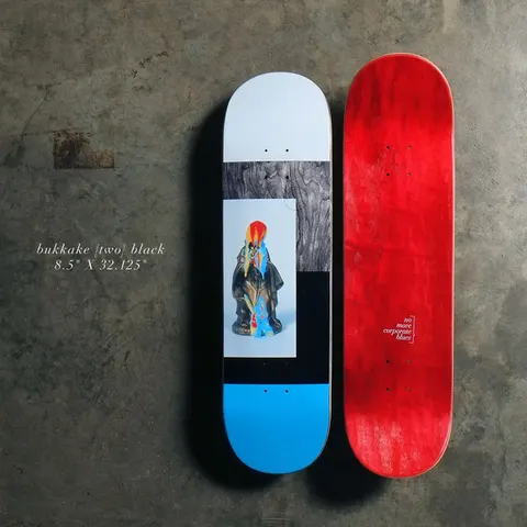Quasi Bukkake - Black skateboard deck: Photographic collage: a small bright figurine in a dark robe on a pale panel, framed by grey wood-grain, black and pale grey blocks with a bright blue tail. The red-stained bottom face sits beside it with a small 'no more corporate blues' mark.