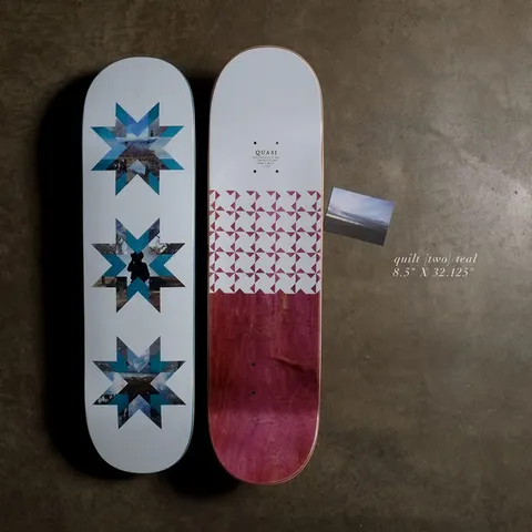 Quasi Quilt - Teal skateboard deck: Pale blue-grey deck with three vertical eight-pointed quilt stars filled with landscape and street photographs in teal and blue tones. The underside shows a triangle pattern above a magenta-stained wood finish.