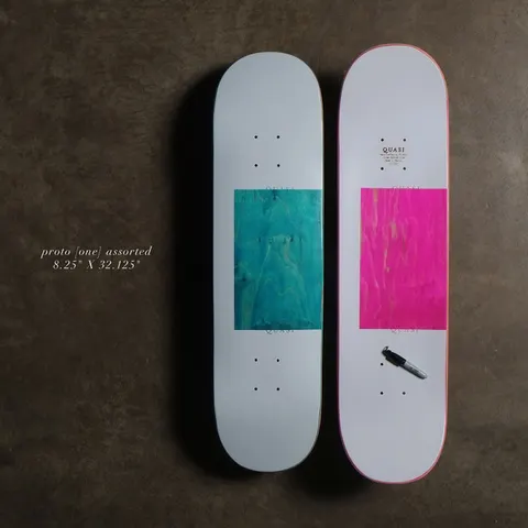 Quasi Proto - Assorted skateboard deck: Plain pale grey deck with a large square of exposed dyed wood veneer, shown in teal on one and hot pink on the other, with small Quasi lettering above and below the square. Two decks shown.