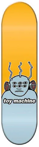 Toy Machine Transmission skateboard deck: A cartoon grey-blue monster with six eyes, stitched mouth, three bent antennae and ear-like speakers, above the Toy Machine wordmark. Orange upper deck fades into pale blue at the base.
