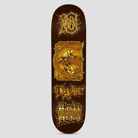 Anti Hero Grant Medieval Brown skateboard deck: Illuminated manuscript style design in gold on brown: a blackletter 18, a decorated G initial containing two pigeons building a brick wall, then the rider surname and Anti Hero in gothic lettering.
