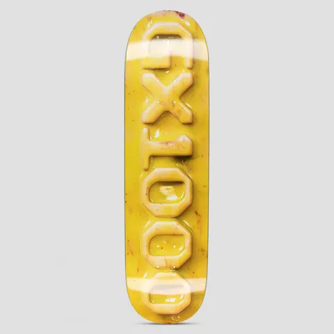 GX1000 Ceramic OG Logo Yellow skateboard deck: The GX1000 name in raised, glossy ceramic-look block letters running vertically down a mottled yellow deck, with a shiny glazed finish.