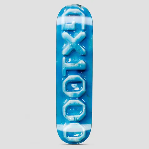 GX1000 Ceramic OG Logo Blue skateboard deck: Large vertical GX1000 logo letters rendered as a glossy, raised ceramic-look relief in pale blue, on a mottled bright blue background with white streaks.