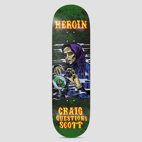 Heroin Craig KO2 Fortune Teller skateboard deck: A hag-like fortune teller in a purple headscarf and blue robe gazes into a crystal ball containing a grinning green creature. Circus-style yellow and red lettering above and below on a dark green mottled deck.
