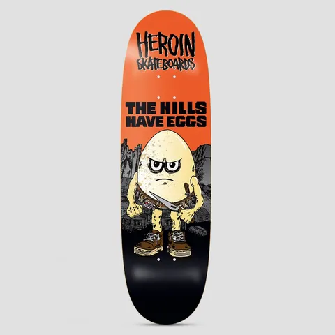 Heroin Hills Have Eggs skateboard deck: Scowling cartoon egg in brown boots with a knife in its belt, standing before rocky hills and ramshackle buildings. Heroin Skateboards logo and 'The Hills Have Eggs' at the top on orange, fading to black.