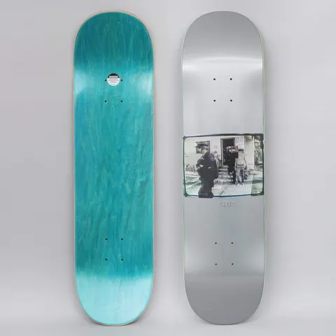Hockey Ricks Silver skateboard deck: Metallic silver deck with a small rectangular grainy photo in the lower middle showing figures in dark clothing outside a house, with faces obscured. Small Hockey text beneath it; teal stained bottom view alongside.