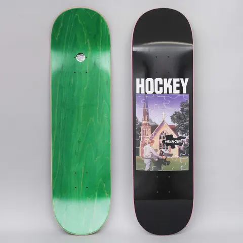 Hockey John Fitzgerald Hellhole Black skateboard deck: White brand name above a jigsaw-style picture of a church and a man in a white shirt touching a black ink-like blob labelled Hellhole, with a dark tree beside. Black deck, green underside shown alongside.
