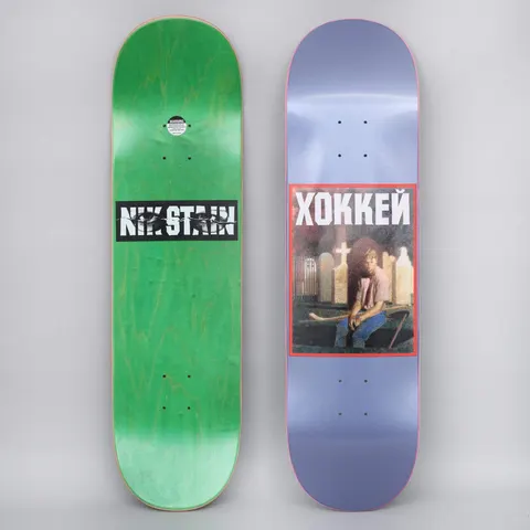Hockey Nik Stain Metallic Blue skateboard deck: Painted portrait of a long-haired person in a pink shirt holding a hockey stick in a graveyard with crosses and headstones, in a red-bordered box under Cyrillic ХОККЕЙ, on a metallic blue deck.
