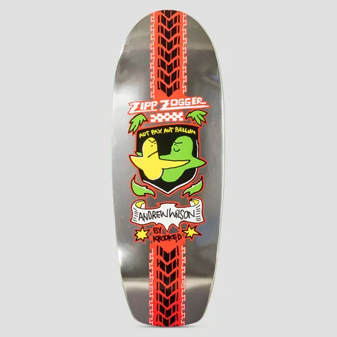Krooked Wilson Pro Zogger Silver skateboard deck: Old-school shaped deck with a red tyre-tread stripe down the middle and a crest showing a yellow and a green blob character embracing, under Zipp Zogger lettering and above a banner with the rider's name. Silver metallic base.